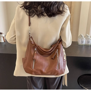Détail du sac cabas en cuir souple marron avec finitions élégantes à double fermeture