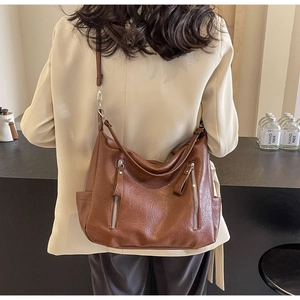 Détail du sac hobo vintage en cuir marron avec double zip et bandoulière ajustable