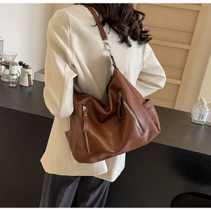 Détail du grand sac cabas en cuir marron foncé avec fermetures éclair et bandoulière