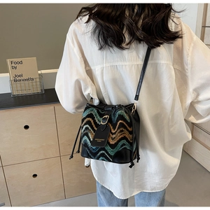 Boho-Beuteltasche mit bunten Wellenmustern und Lederriemen, präsentiert von einem Modell