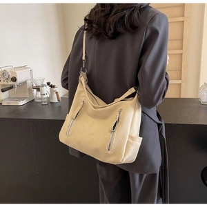 Détail du sac cabas jaune crème avec fermetures éclair argentées et poches