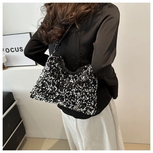 Detail shot of a stylish sequin shoulder bag with knot strap detail on female model