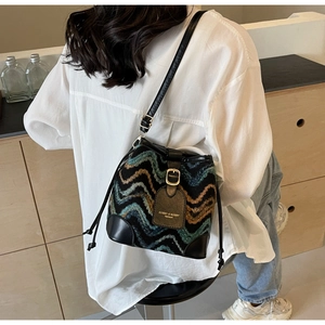 Nahaufnahme eines Modells mit böhmischer Strick-Beuteltasche mit bunten Wellenmustern