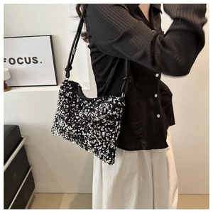 Detail of the sequined bucket bag with black leather knotted shoulder strap on model