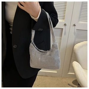 Gros plan d'un sac à main argenté scintillant porté par un mannequin en veste