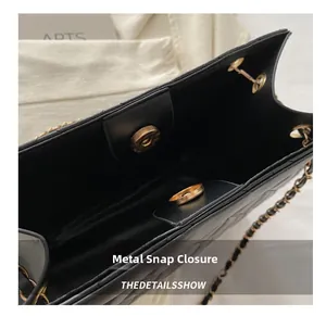 Gros plan détaillé du fermoir magnétique sur le sac à bandoulière matelassé noir