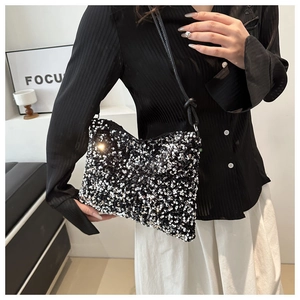Close-up of stylish bucket bag with black and white sequins and leather shoulder strap