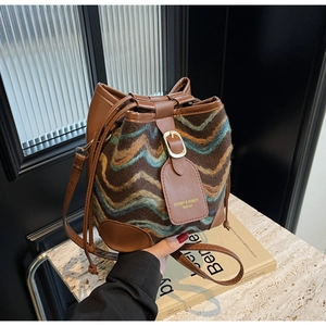 Nahaufnahme der Boho-Strick-Beuteltasche mit Wellenmuster und braunem Lederbesatz im Detail