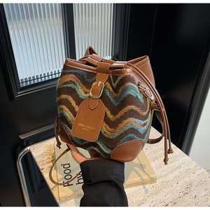 Detail der Boho-Beuteltasche mit Wellenmuster-Stoff und braunem Lederbesatz