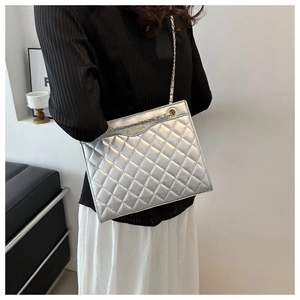 Détail du sac argenté matelassé avec chaîne dorée et motif à losanges sophistiqué