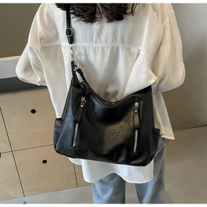 Vue détaillée du dos d'un sac cabas en cuir souple noir avec doubles poches zippées pratiques
