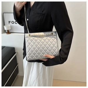 Détail du sac matelassé argenté avec finition métallisée et lettrage doré de marque