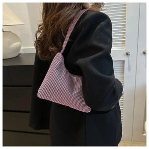 Détail du sac à main rose serti de strass sur un blazer noir au fini scintillant