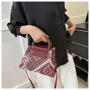 Detailed shot of ethnic canvas handbag with wooden handle and vintage woven geometric patterns