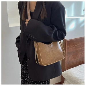 Détail d'un sac seau hobo en cuir PU marron vintage avec surpiqûres verticales chic