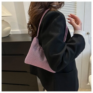 Détail du sac hobo rose à strass sur l'épaule, montrant la texture scintillante