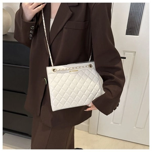 Gros plan du sac matelassé blanc en cuir avec chaîne dorée et détails du logo chic