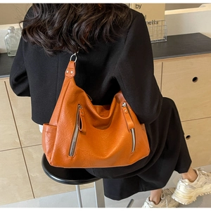 Détail du sac cabas en cuir synthétique marron orangé avec fermetures éclair métalliques
