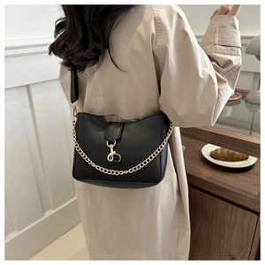 Primer plano de bolso retro negro con textura brillante y detalle de cadena dorada