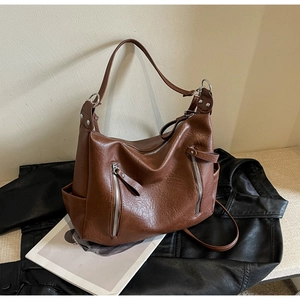Détail du sac hobo marron vintage avec texture en cuir souple et doubles zips frontaux