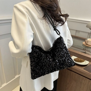 Chic black sequin bucket bag with knotted shoulder strap worn with a white blazer