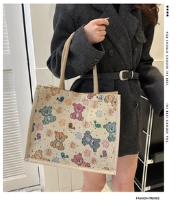 Détail du sac cabas en toile avec motifs d'ours colorés et anses en tissu beige