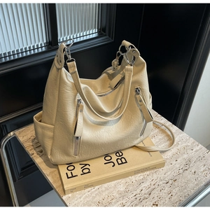 Détail du sac hobo beige avec texture cuir galet et poches à fermeture éclair argentée