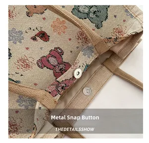 Détail du fermoir magnétique d'un sac cabas en toile tissée avec motif d'ours brodé