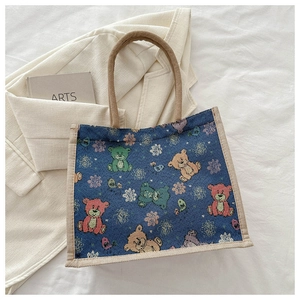 Gros plan détaillé du sac cabas en toile bleue avec motifs d'ours et anses en corde de chanvre