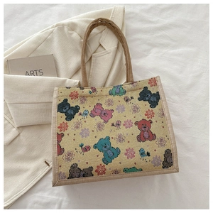 Détail de l'imprimé ours et fleurs sur le sac cabas en toile tissée jaune vif