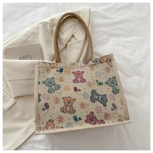 Détail du sac cabas en jute beige avec motifs d'ours colorés et anses en corde