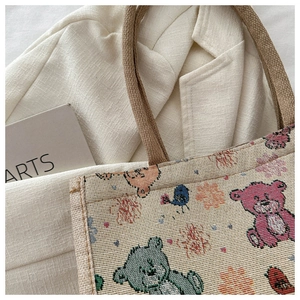 Détail d'un sac cabas en toile tissée avec motif d'ours et anse en corde tressée