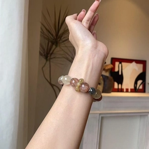 Natural multi-color crystal beaded bracelet with gold rutilated quartz on woman wrist