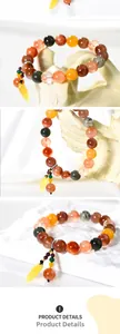 Close-up of multicolor natural stone beads with yellow leaf pendant and metallic details