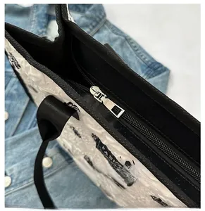 Détail de la fermeture éclair noire sur un sac cabas en toile blanche texturée