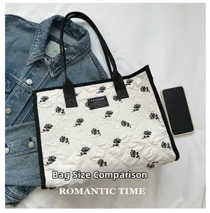 Détail du sac cabas matelassé blanc avec motifs de roses noires et logo FASHION brodé