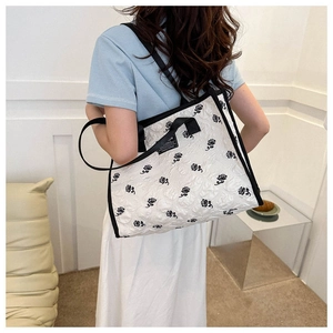 Détail du sac cabas matelassé blanc cassé avec broderie de rose noire et sangle