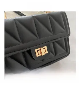 Detail shot of black quilted leather shoulder bag with gold twist lock closure and stitching