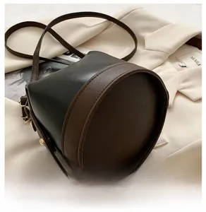 Λεπτομερής κάτω όψη της δίχρωμης τσάντας bucket από μαύρο και καφέ δέρμα PU υψηλής ποιότητας
