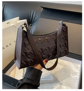 Detailed view of dark brown embossed leather shoulder bag in luxury gift box
