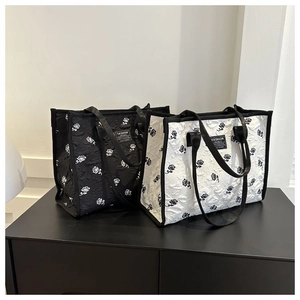 Détail de grands sacs fourre-tout à motif rose 3D et anses en cuir noir et blanc