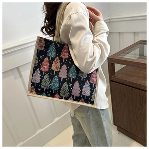 Détail du sac cabas tissé avec motifs de sapins de Noël colorés sur fond bleu marine