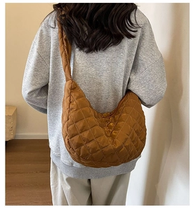 Detailed close-up of brown quilted nylon crescent bag with elegant diamond stitching texture
