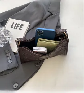 Detail view of large interior capacity for dark brown shoulder bag with relief texture