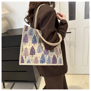 Détail du cabas en toile avec motifs d'arbres de Noël colorés et poignées tissées