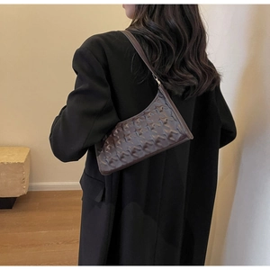 Detail of dark brown underarm bag featuring embossed star texture on faux leather