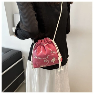 Detail of pink embroidered bucket bag with cherry blossoms and cotton drawstring strap