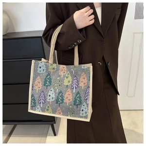 Détail du sac cabas en toile avec imprimés sapins de Noël colorés et anses tissées