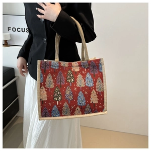 Détail du sac cabas de Noël en jute avec motifs de sapins rouges et anses tissées