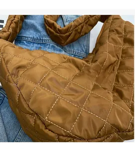 Detail of brown quilted nylon tote bag showing soft diamond stitching and padded texture